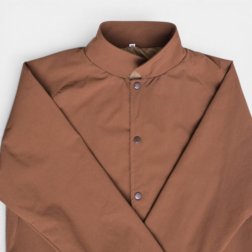 Brown button varsity terry jacket folded flat lay, close-up of snap buttons