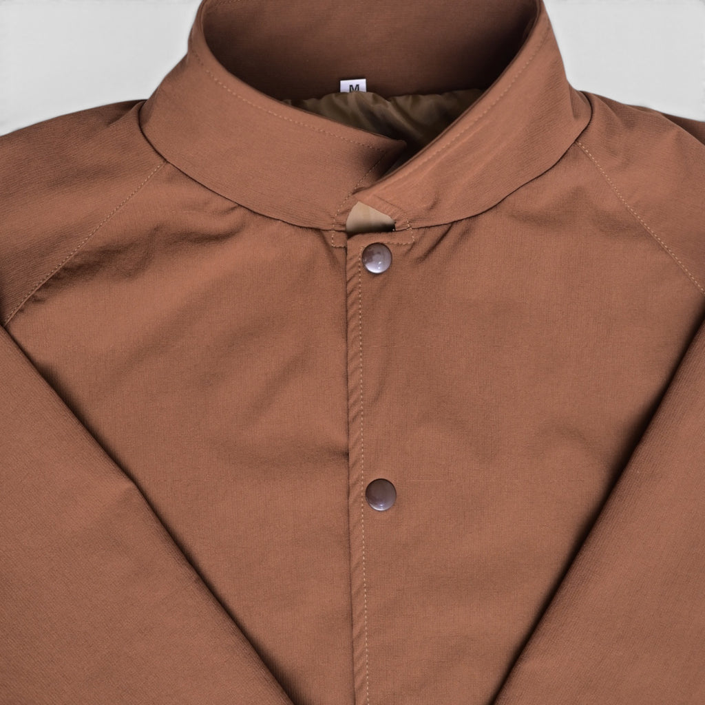 Close-up of brown varsity jacket collar and snap button closure