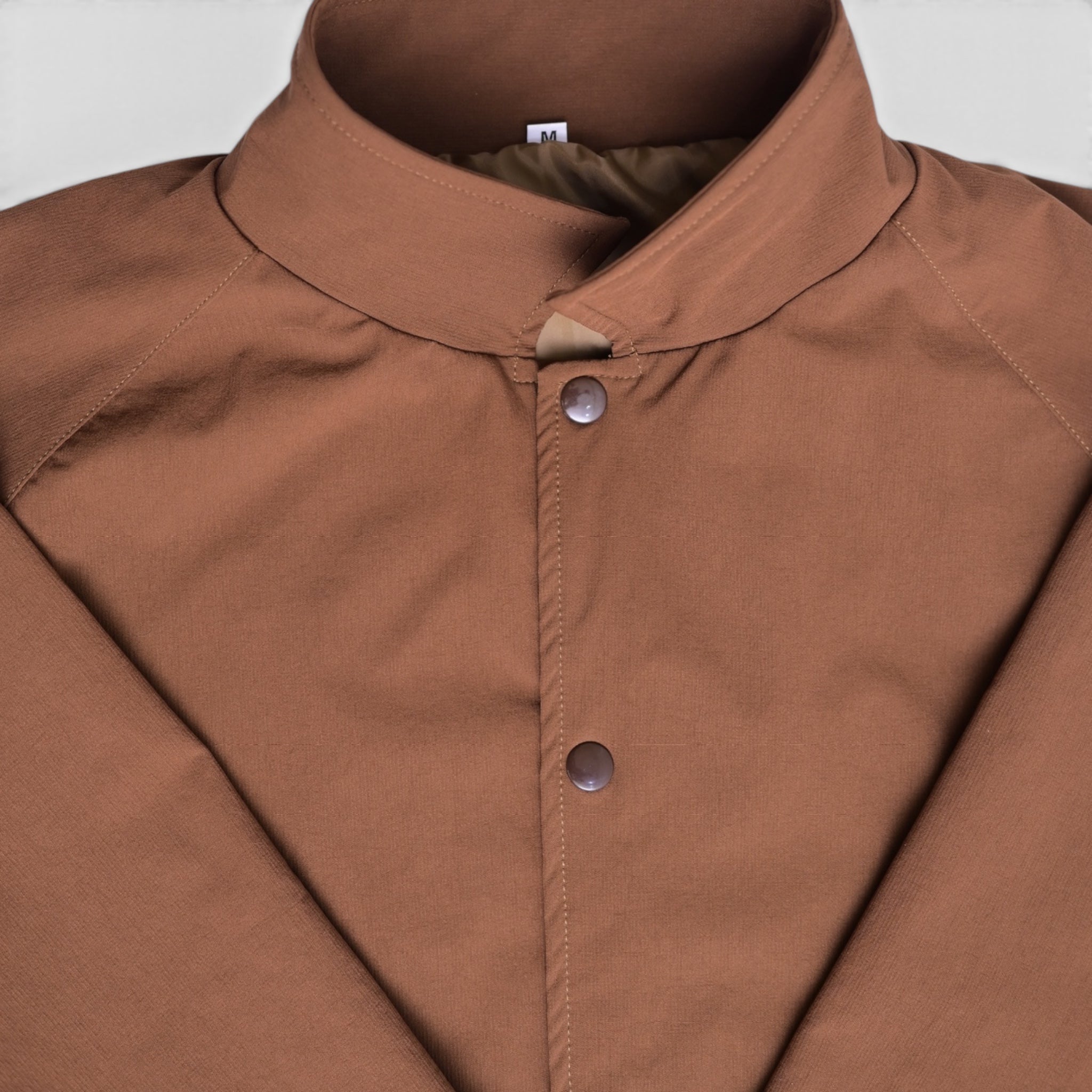Close-up of brown varsity jacket collar and snap button closure