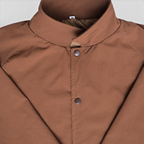 Close-up of brown varsity jacket collar and snap button closure